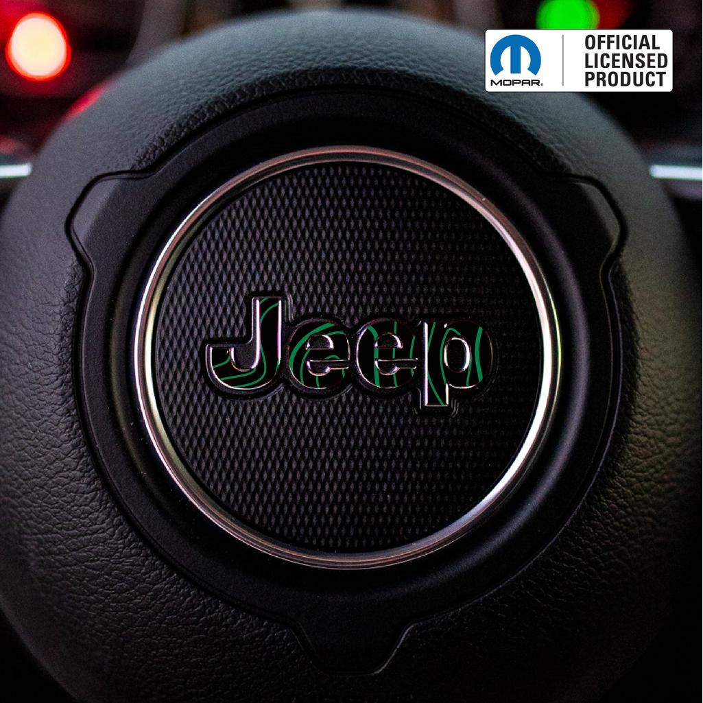 Close-up of a green topo Jeep logo on a steering wheel with Mopar branding.