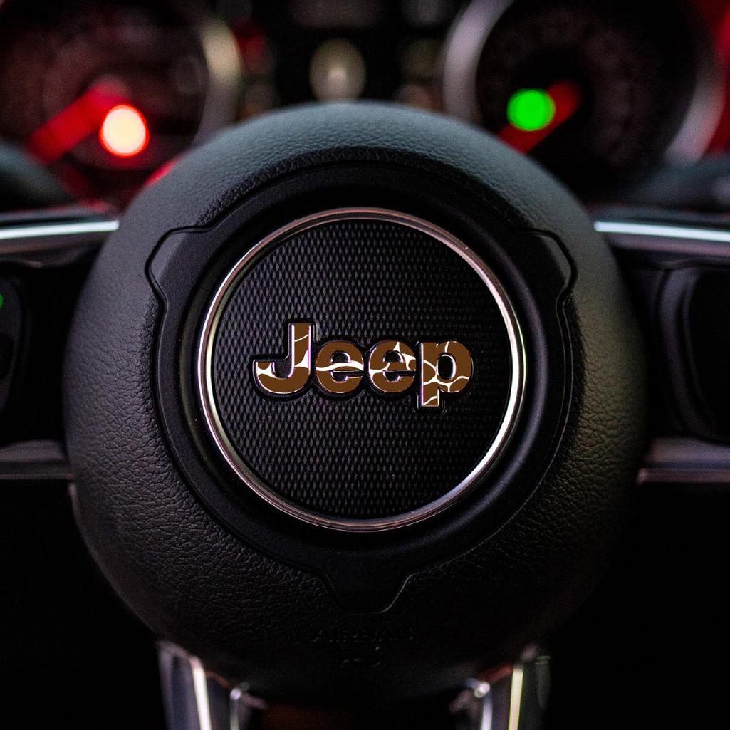 Close-up of a cow print Jeep steering wheel emblem with a blurred dashboard in the background
