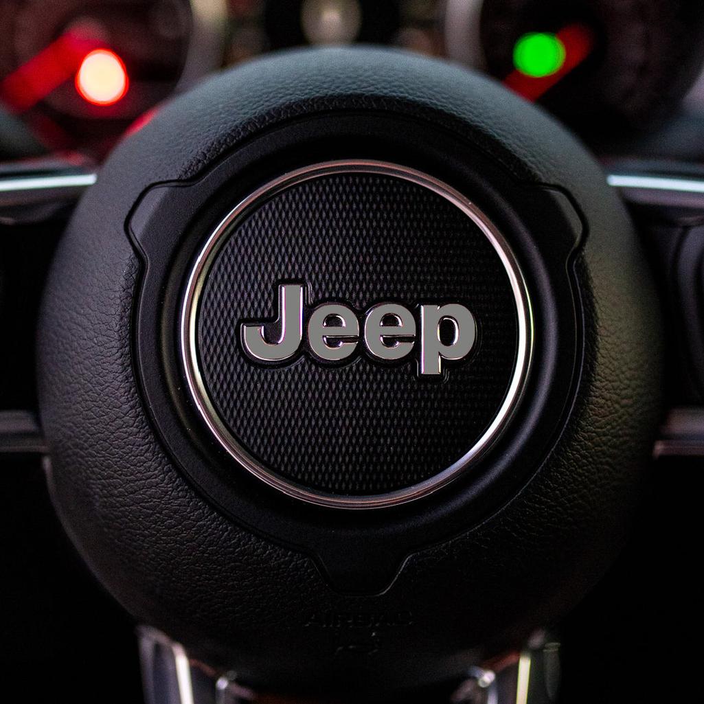 Close-up of a Jeep steering wheel emblem with blurred background