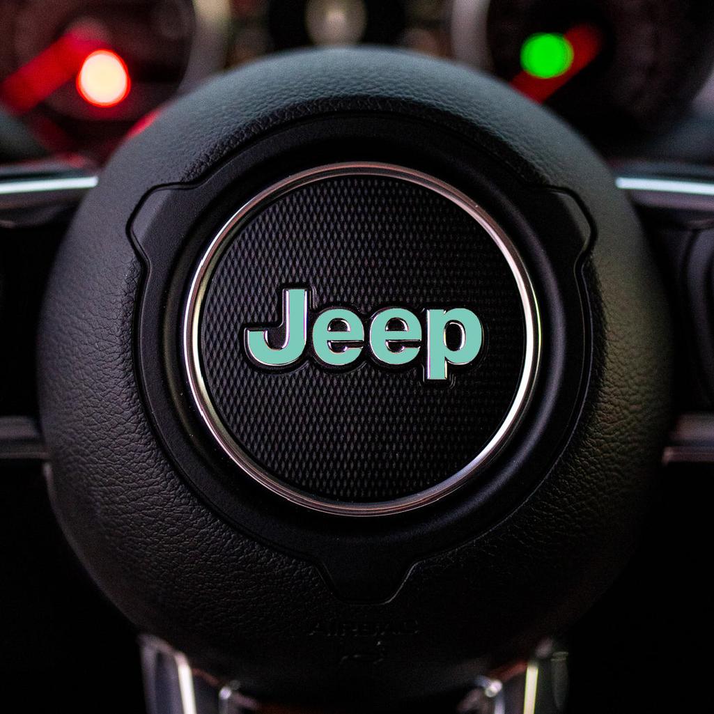 Steering wheel with mint Jeep logo in a car interior