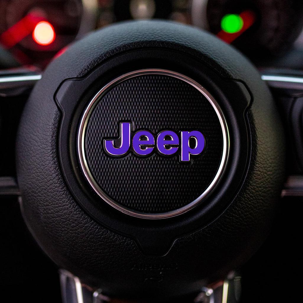 Steering wheel with purple Jeep logo in a car interior