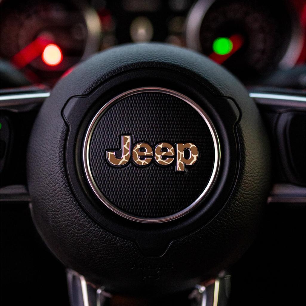 Close-up of a giraffe Jeep logo on a car steering wheel with a blurred background