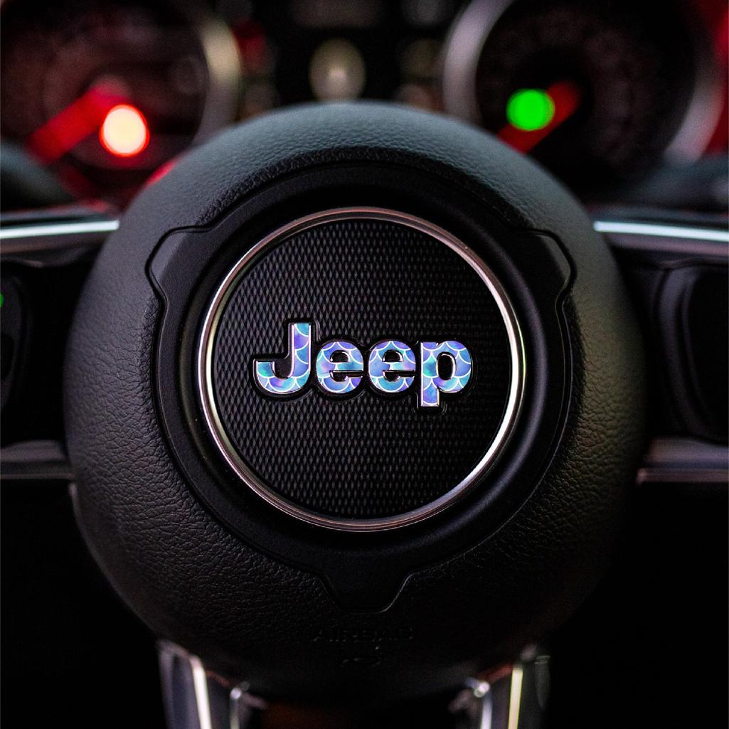 Close-up of a mermaid Jeep steering wheel emblem with blurred dashboard in the background