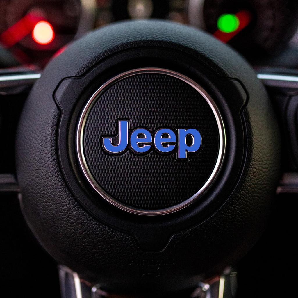 Steering wheel with blue Jeep logo in a car interior