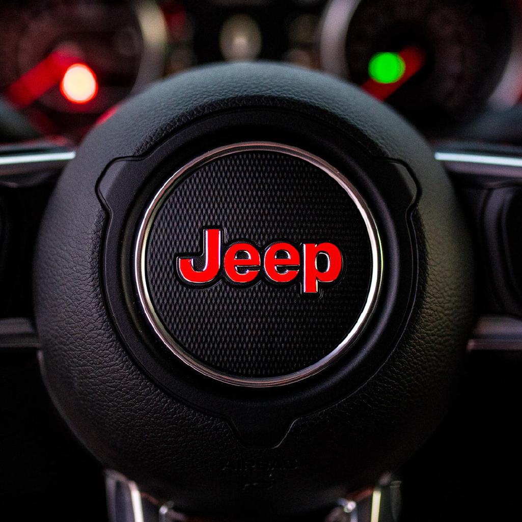 Steering wheel with red Jeep logo in a car interior